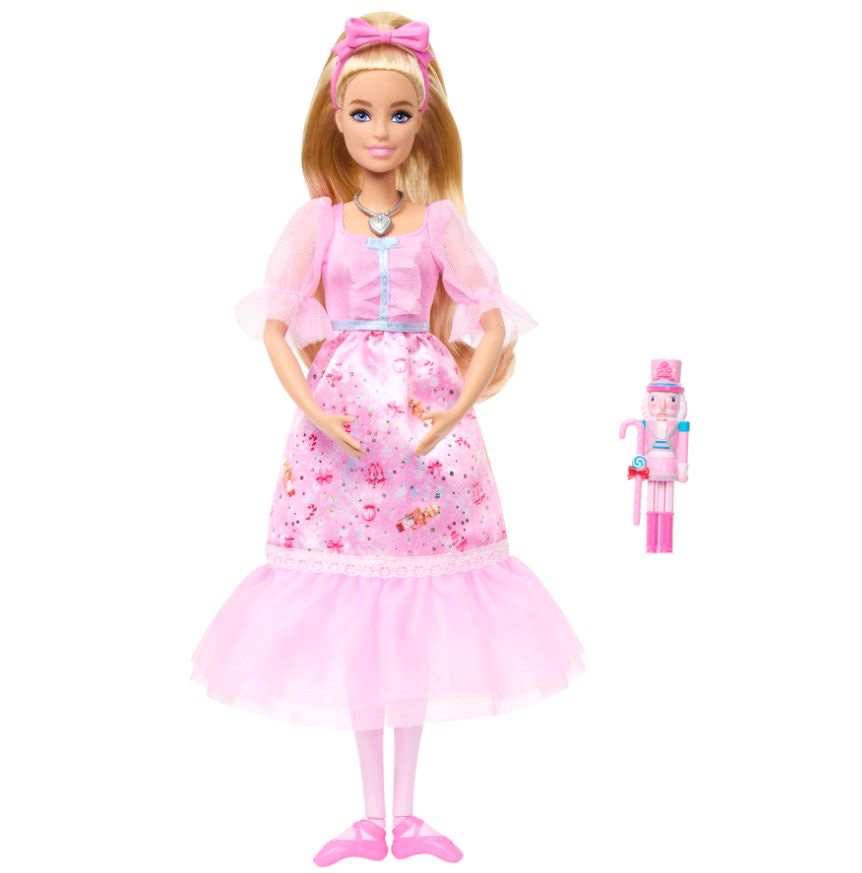 Mattel-Pressebild: blonde Clara-Puppe JLW51 in rosa Kleid mit Tüllärmeln und Medaillon-Kette, daneben ein kleiner rosa Spielzeug-Nussknacker