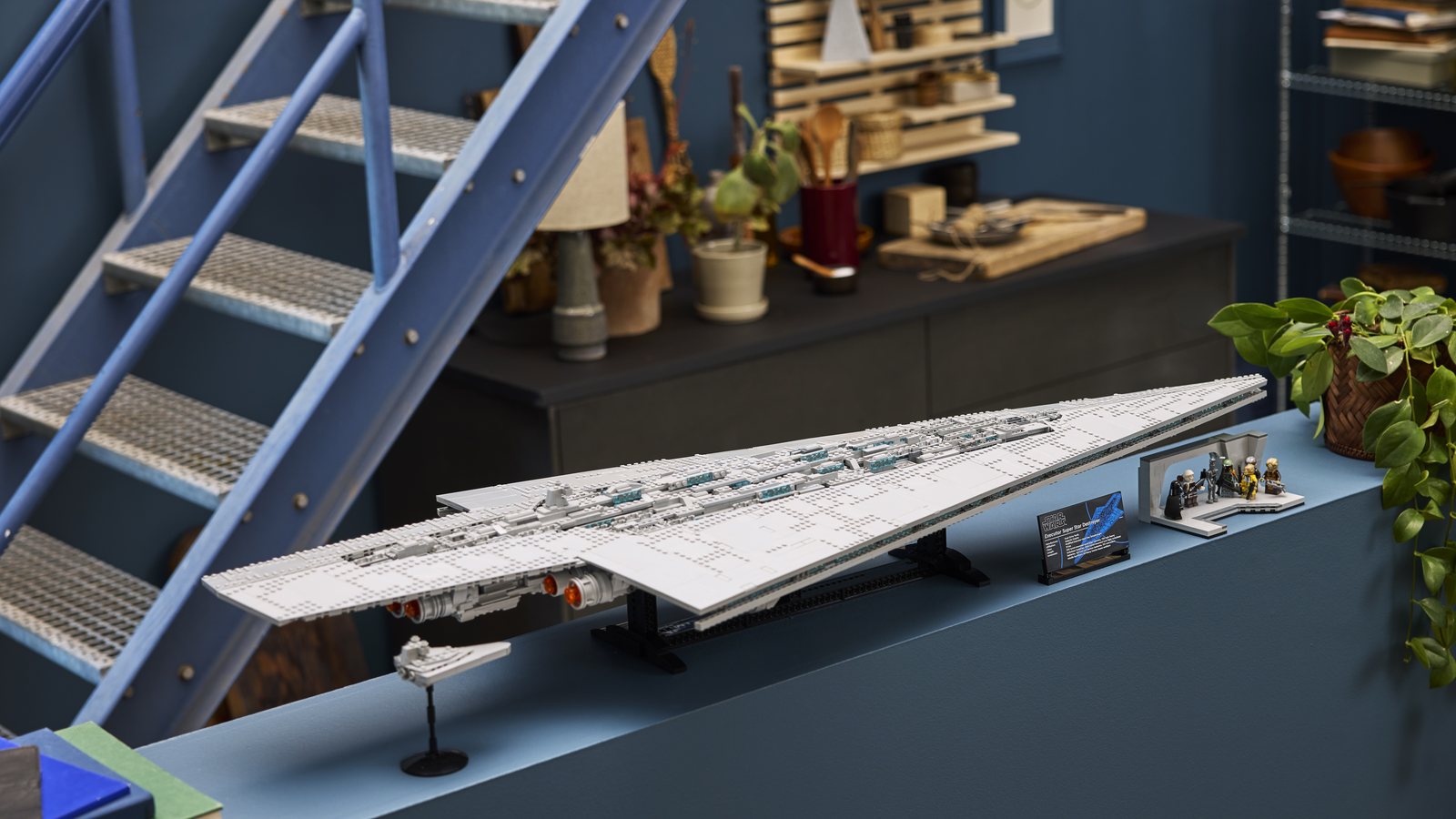 Das LEGO Modell Supersternzerstörer Executor 75457 auf einer langen Ablage, daneben ein kleiner Sternzerstörer, die Infotafel und die Brückenszene mit sieben Minifiguren