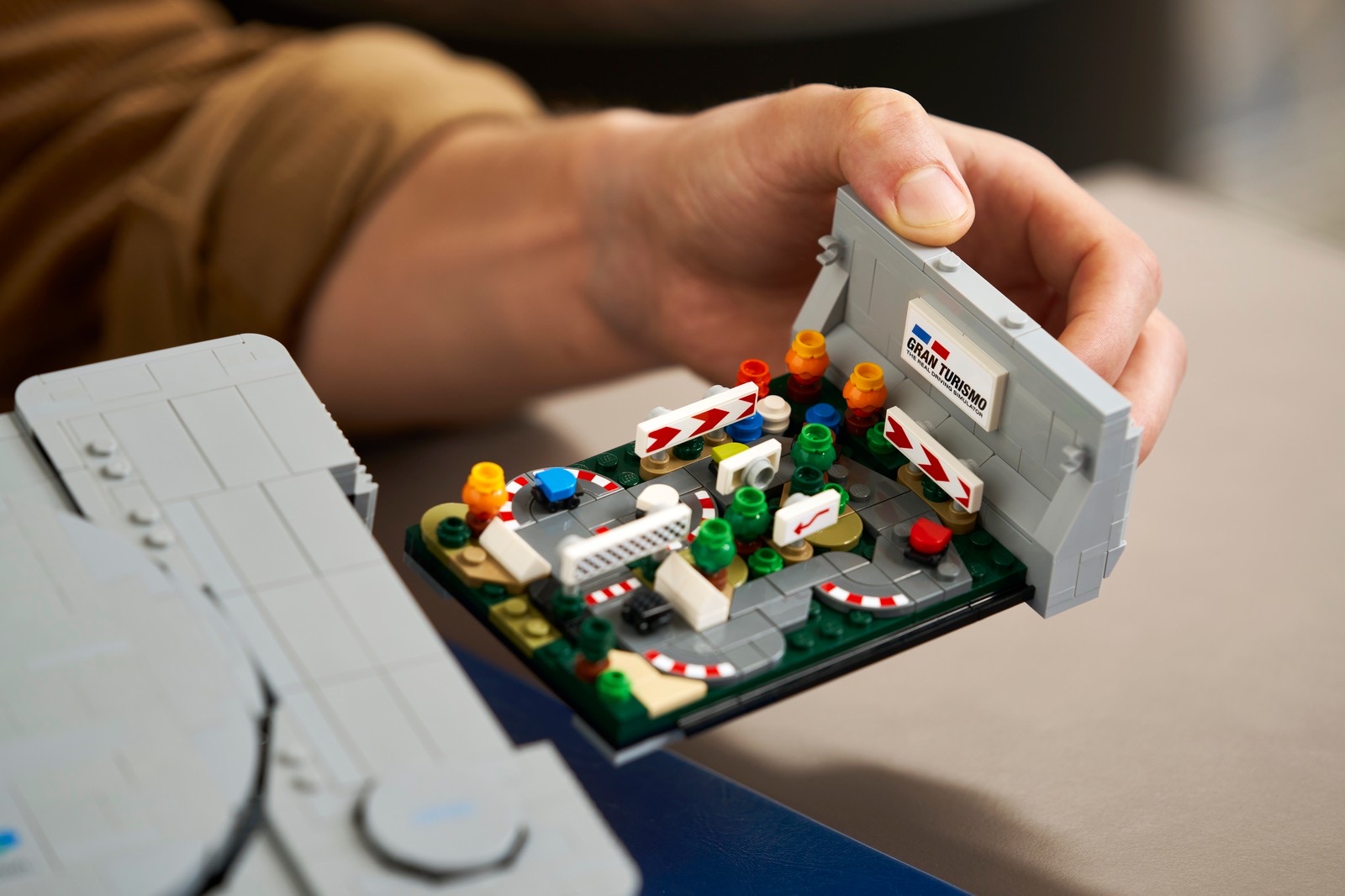 Das herausgezogene Gran-Turismo-Diorama des LEGO PlayStation Sets in einer Hand